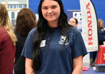 A woman with black hair and a navy t-shirt.