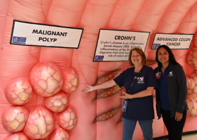 Two women point to an inflatable indicating a "malignant polyp."