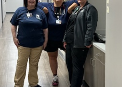 Three women in black stand posed together