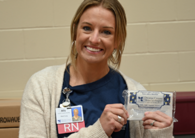 A woman with blond hair and a blue shirt holds a bag of popcorn