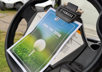 Program clipped to a golf cart steering wheel