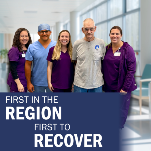 A woman with brown curly hair and purple scrubs, a man in light blue scrubs with glasses, a woman with blonde hair and purple scrubs, a man with a gray t-shirt and glasses, and a woman with brown hair pulled into a pony tail and purple scrubs stand posed together for a photo.